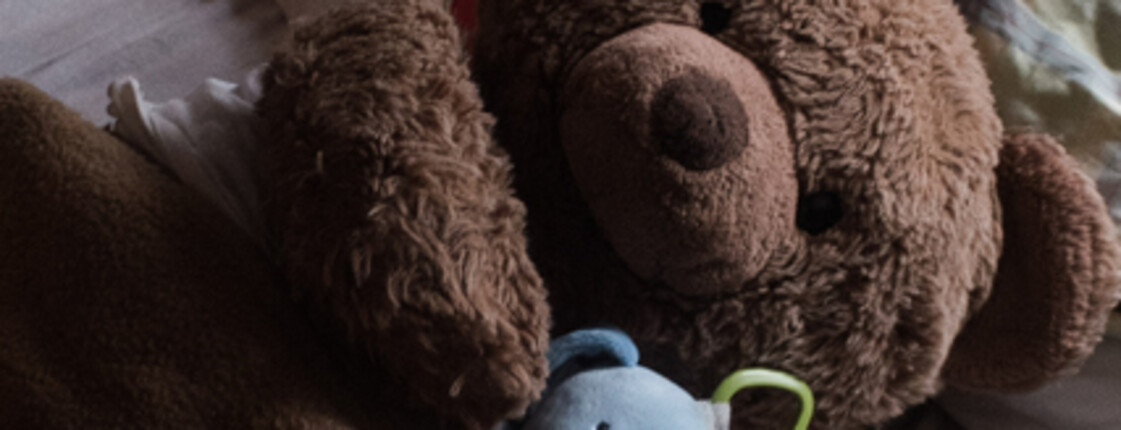 Zwei Teddybären auf einem schlichten Kinderbett